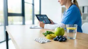 Consultation médicale avec pilules et fruits illustrant médicament maigrir vite